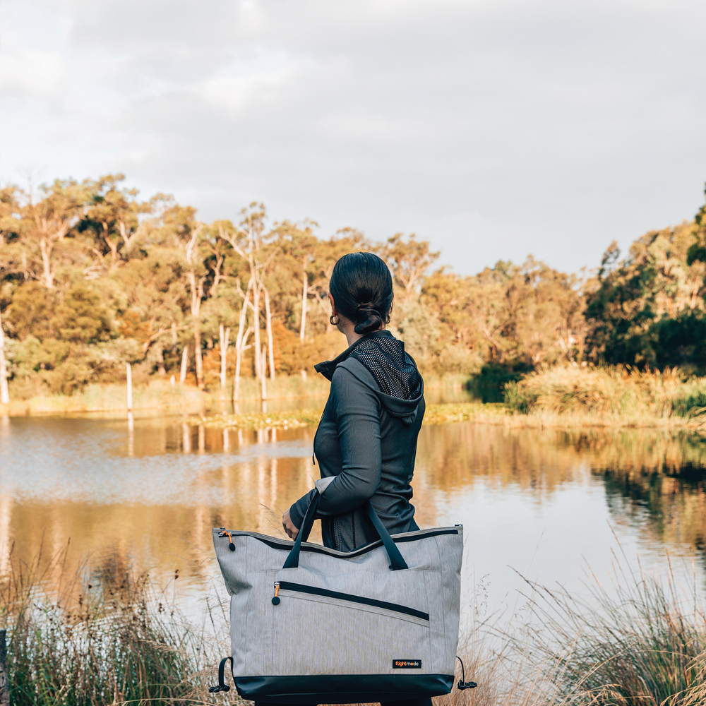 woman in forest with travel duffel bag